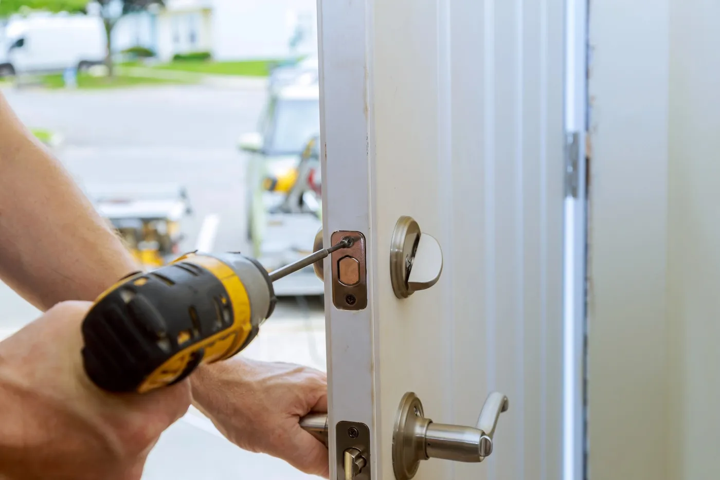 Serrurier perçant et installant une serrure sur une porte d'entrée en Île-de-France